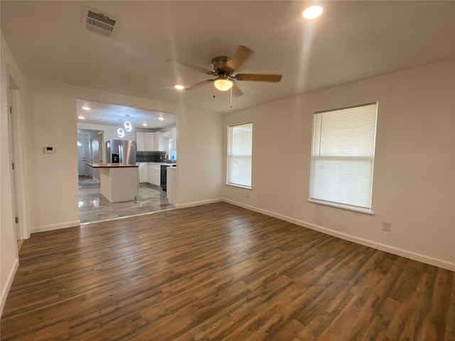 unfurnished living room with dark wood-type flooring and ceiling fan