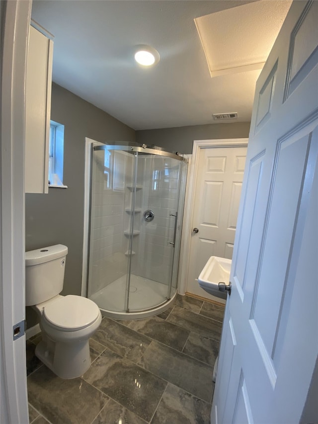 bathroom with toilet and an enclosed shower