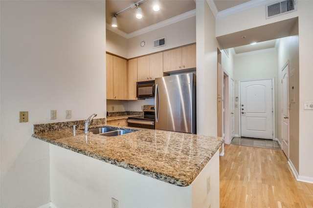 kitchen featuring sink, light stone counters, light brown cabinets, appliances with stainless steel finishes, and kitchen peninsula