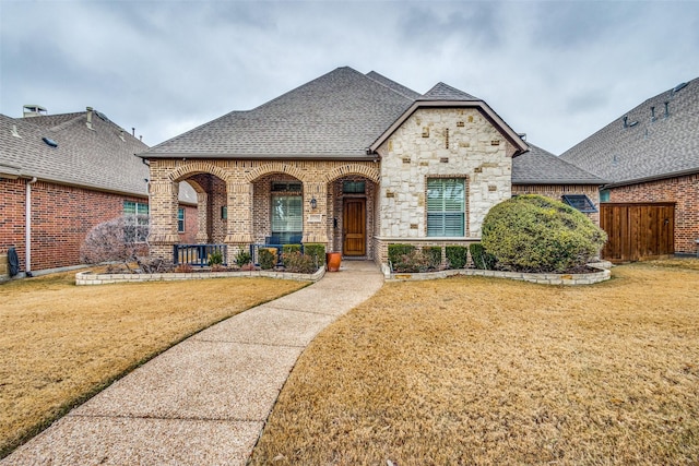 french provincial home featuring a front lawn and covered porch