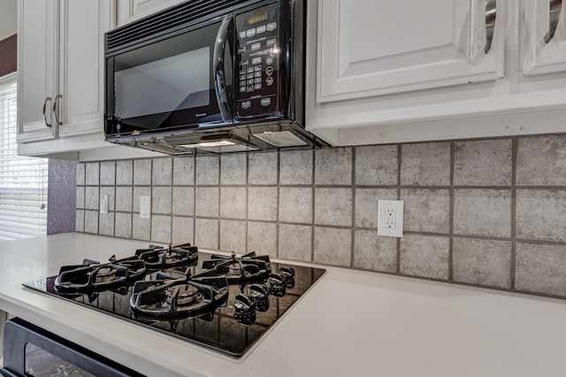 details featuring backsplash, black appliances, light countertops, and white cabinetry