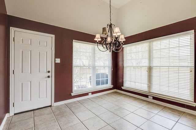 unfurnished dining area with light tile patterned floors, a chandelier, baseboards, and vaulted ceiling