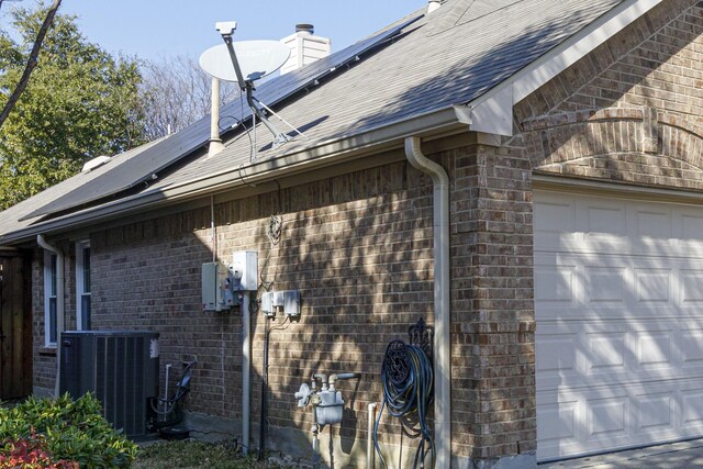 view of front facade featuring central AC unit and a garage