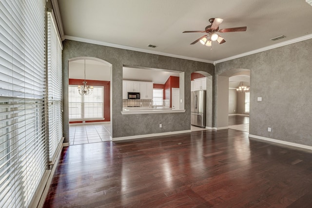 unfurnished living room with visible vents, arched walkways, dark wood-style floors, and ceiling fan with notable chandelier