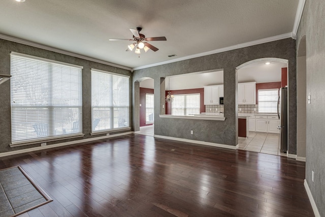 unfurnished living room featuring arched walkways, light wood-style floors, and ornamental molding