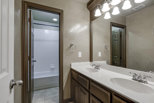 full bath with tile patterned flooring, a textured wall, visible vents, and a sink