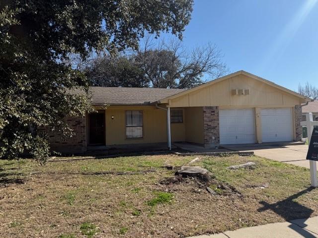 ranch-style home with a garage and a front lawn