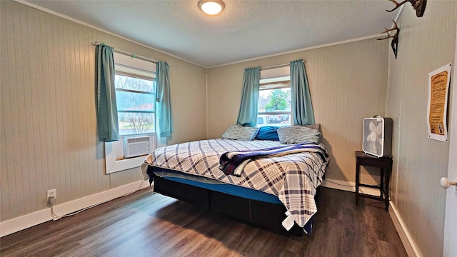 bedroom with ornamental molding, cooling unit, a textured ceiling, and dark hardwood / wood-style flooring