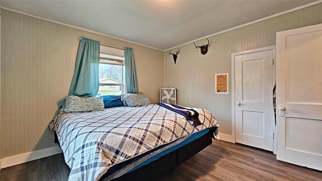 bedroom with dark wood-type flooring, crown molding, and a textured ceiling