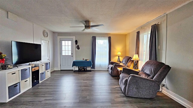 living room with ceiling fan, dark hardwood / wood-style floors, and a textured ceiling