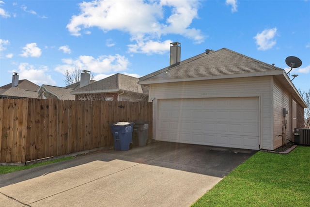 view of side of property with central AC unit, a garage, and an outdoor structure