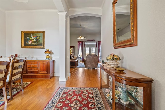 entrance foyer featuring ornamental molding, light hardwood / wood-style floors, ceiling fan, and ornate columns