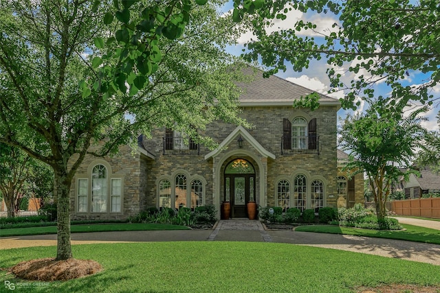 view of front of home with a front lawn and french doors