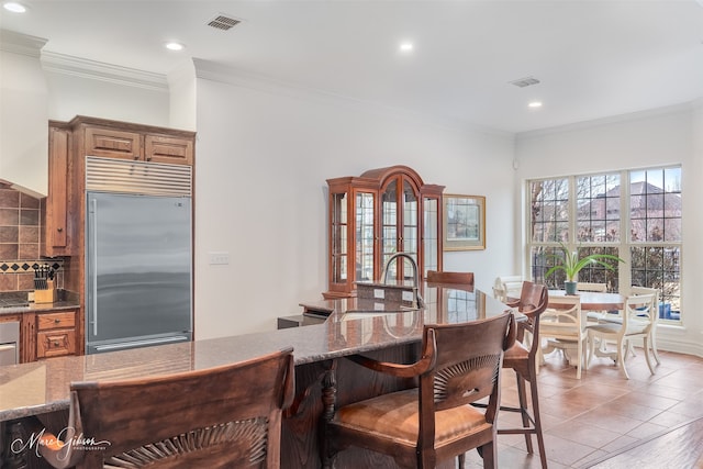 tiled dining room featuring crown molding