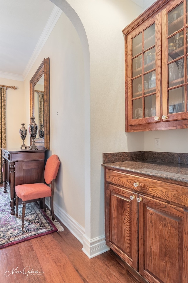 corridor with hardwood / wood-style flooring and ornamental molding