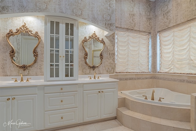 bathroom featuring tile patterned floors, vanity, and tiled bath