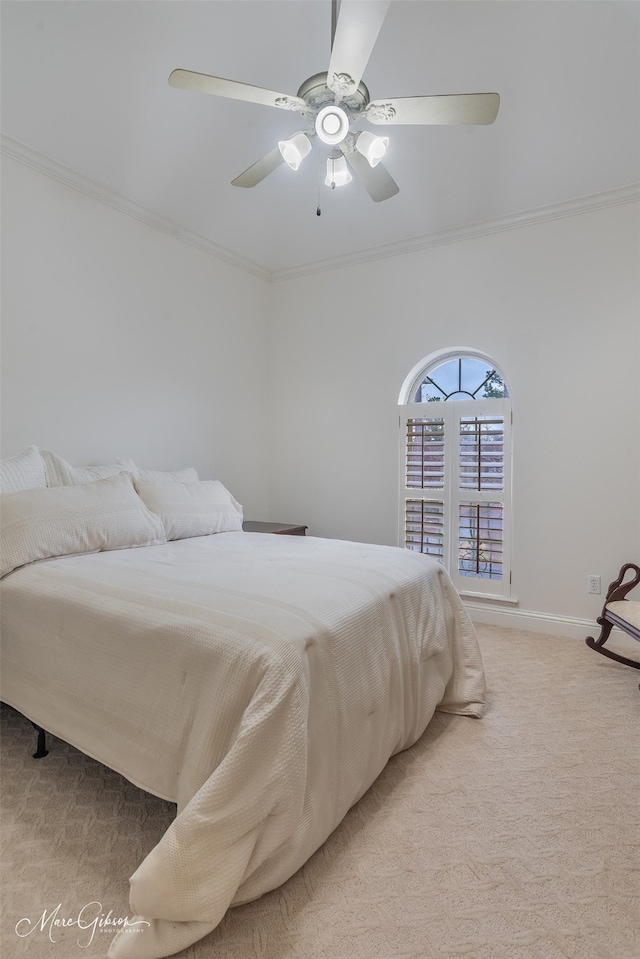 carpeted bedroom with ornamental molding and ceiling fan