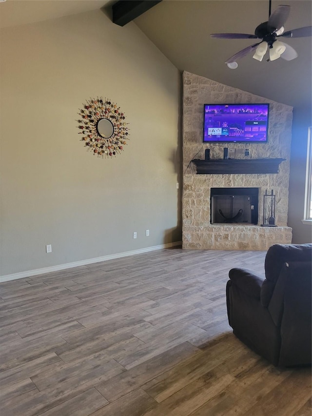 living room featuring lofted ceiling with beams, wood-type flooring, ceiling fan, and a fireplace