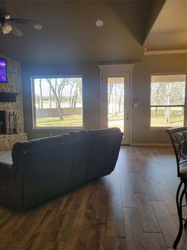 living room with hardwood / wood-style flooring, a fireplace, crown molding, and ceiling fan