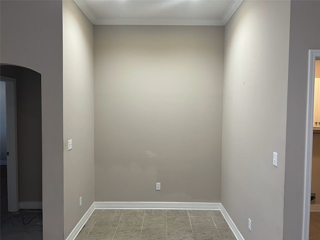 spare room with ornamental molding, arched walkways, and baseboards