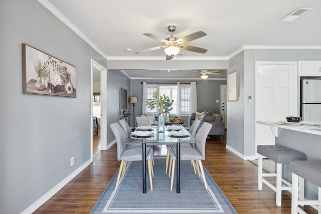 dining space featuring dark wood-type flooring and crown molding