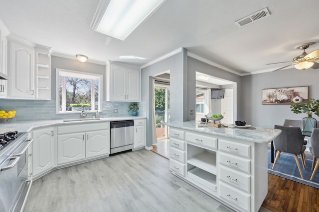 kitchen featuring sink, a wealth of natural light, stainless steel appliances, light hardwood / wood-style floors, and white cabinets