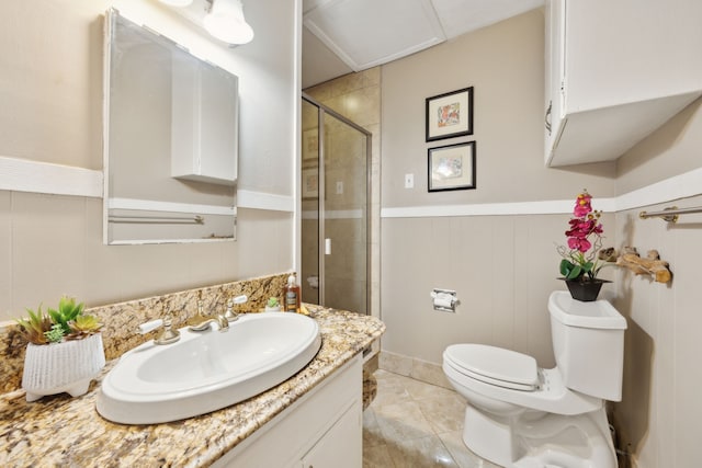 bathroom featuring vanity, a shower with shower door, and toilet