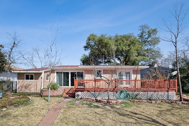 back of house featuring a wooden deck and a yard