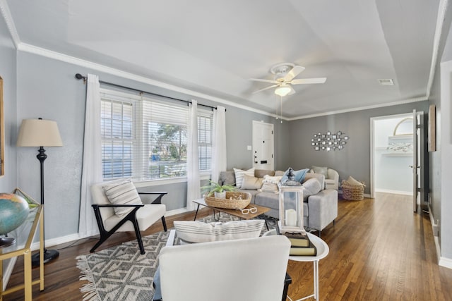 living room featuring crown molding, ceiling fan, a tray ceiling, and dark hardwood / wood-style flooring