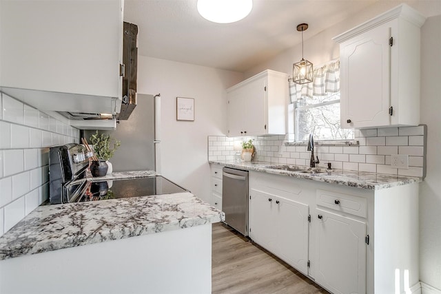 kitchen featuring sink, white cabinetry, hanging light fixtures, light wood-type flooring, and stainless steel dishwasher