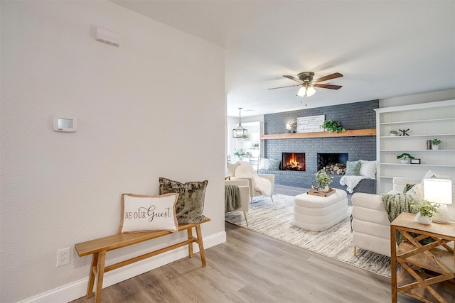 living room with ceiling fan, hardwood / wood-style floors, and a fireplace