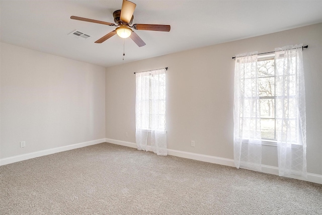 empty room featuring carpet floors, a wealth of natural light, and ceiling fan