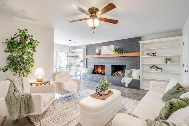 living room featuring ceiling fan, a fireplace, and hardwood / wood-style floors