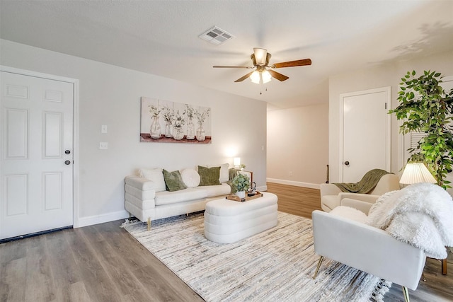 living room featuring hardwood / wood-style floors and ceiling fan