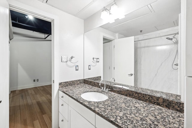 bathroom featuring vanity, wood-type flooring, and a shower