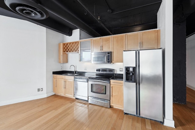 kitchen featuring appliances with stainless steel finishes, sink, light brown cabinets, and light hardwood / wood-style floors