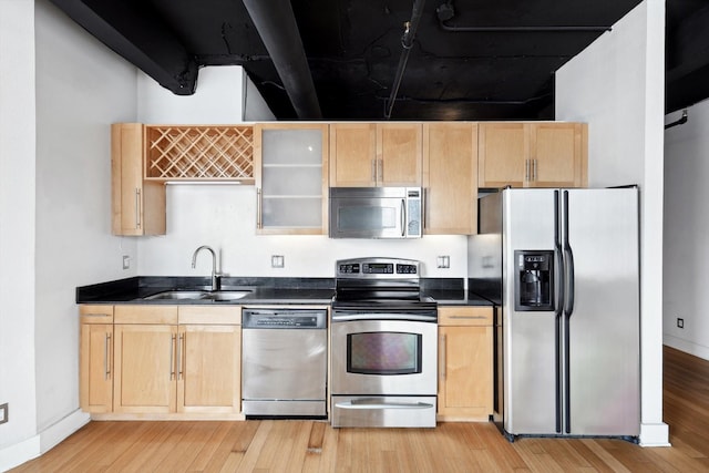 kitchen with appliances with stainless steel finishes, light hardwood / wood-style floors, sink, and light brown cabinets