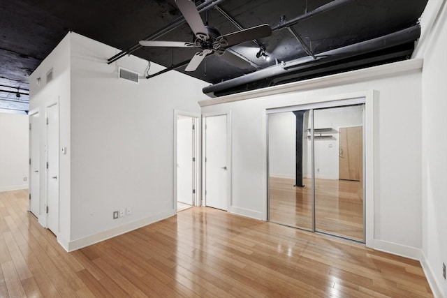 unfurnished bedroom with ceiling fan, two closets, and light hardwood / wood-style floors