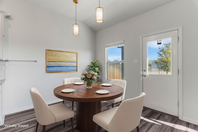 dining area featuring lofted ceiling and dark hardwood / wood-style flooring