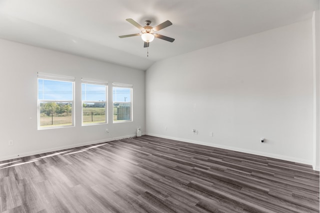 spare room featuring dark wood-type flooring, ceiling fan, and vaulted ceiling