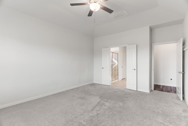 unfurnished bedroom with ceiling fan, ensuite bathroom, and light carpet