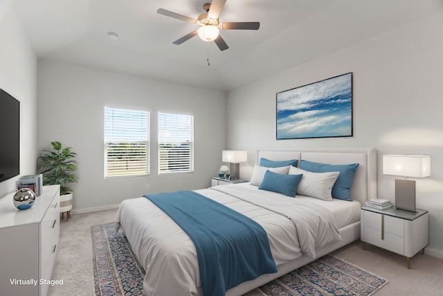 carpeted bedroom featuring ceiling fan and a tray ceiling