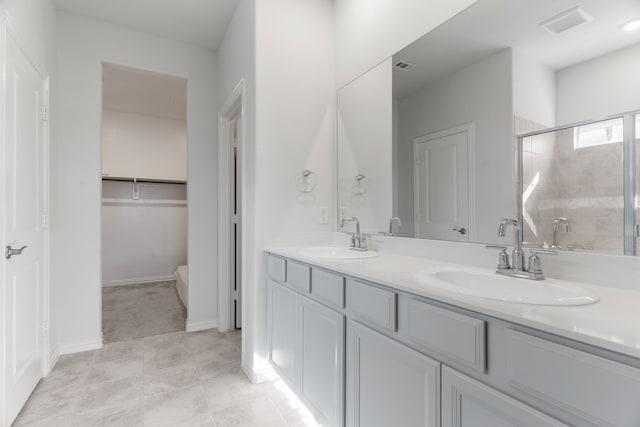 bathroom featuring tile patterned floors, vanity, and a shower with shower door