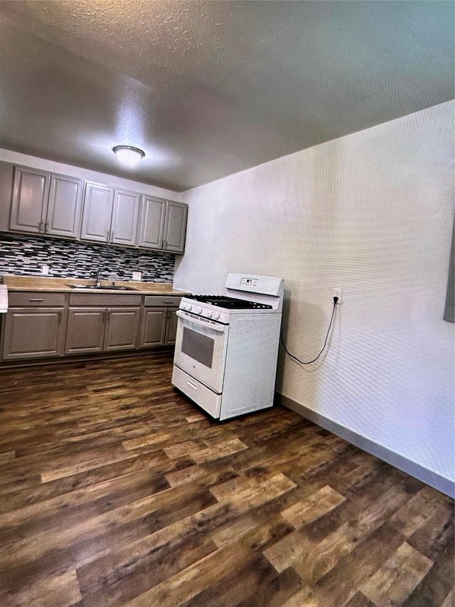 kitchen with sink, gray cabinetry, dark hardwood / wood-style floors, and gas range gas stove