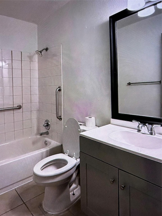 full bathroom featuring tile patterned flooring, vanity, tiled shower / bath combo, and toilet