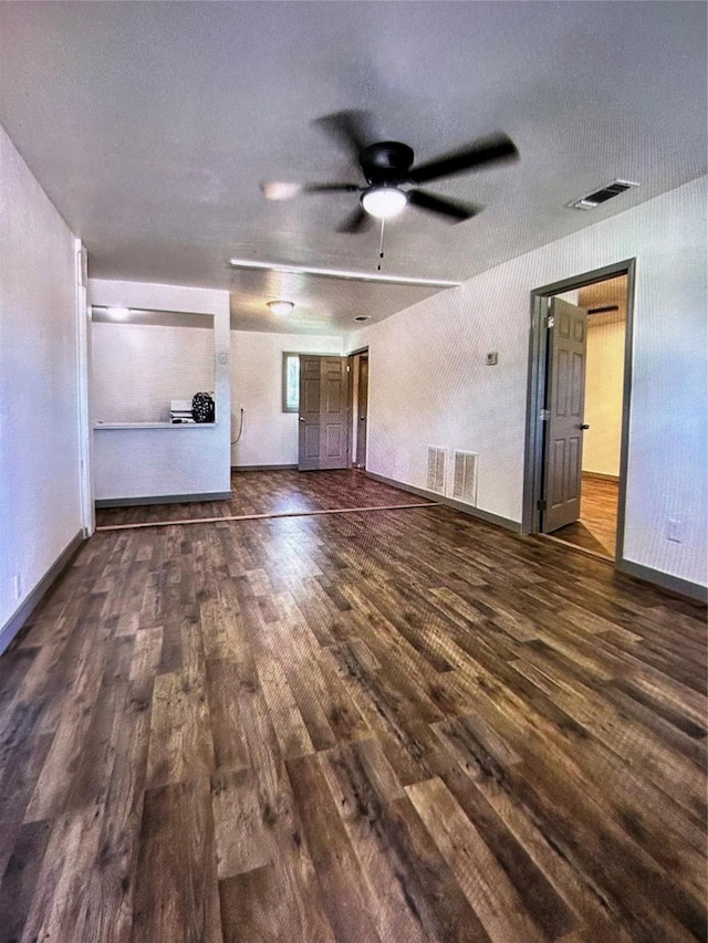 unfurnished living room featuring ceiling fan and dark hardwood / wood-style flooring