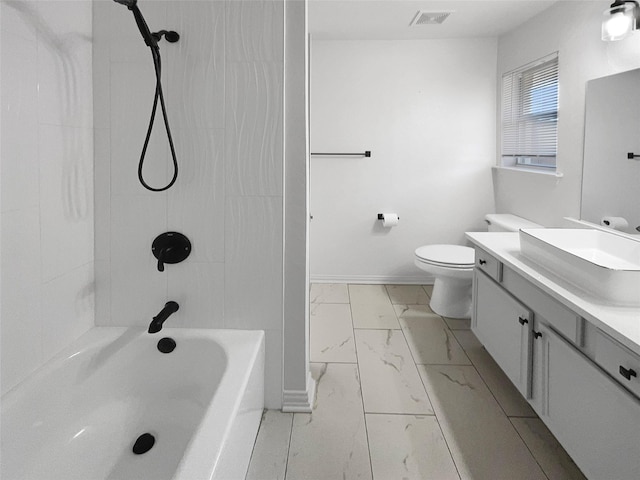 full bathroom featuring tiled shower / bath, vanity, and toilet