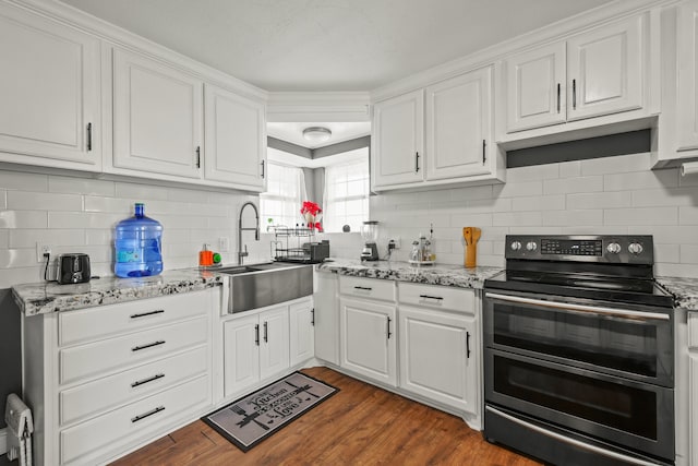 kitchen with sink, white cabinets, dark hardwood / wood-style flooring, range with two ovens, and light stone countertops