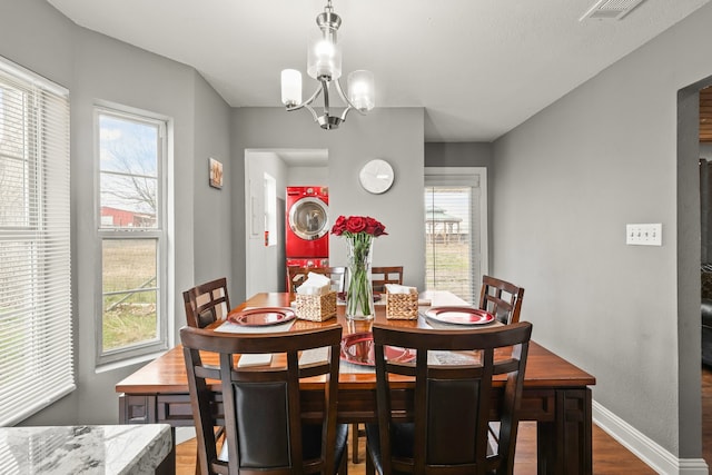 dining room featuring dark wood-type flooring and a chandelier