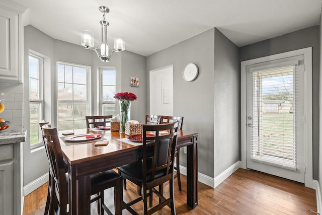 dining area with a notable chandelier and light hardwood / wood-style flooring